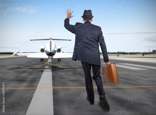Business man running behind a plane