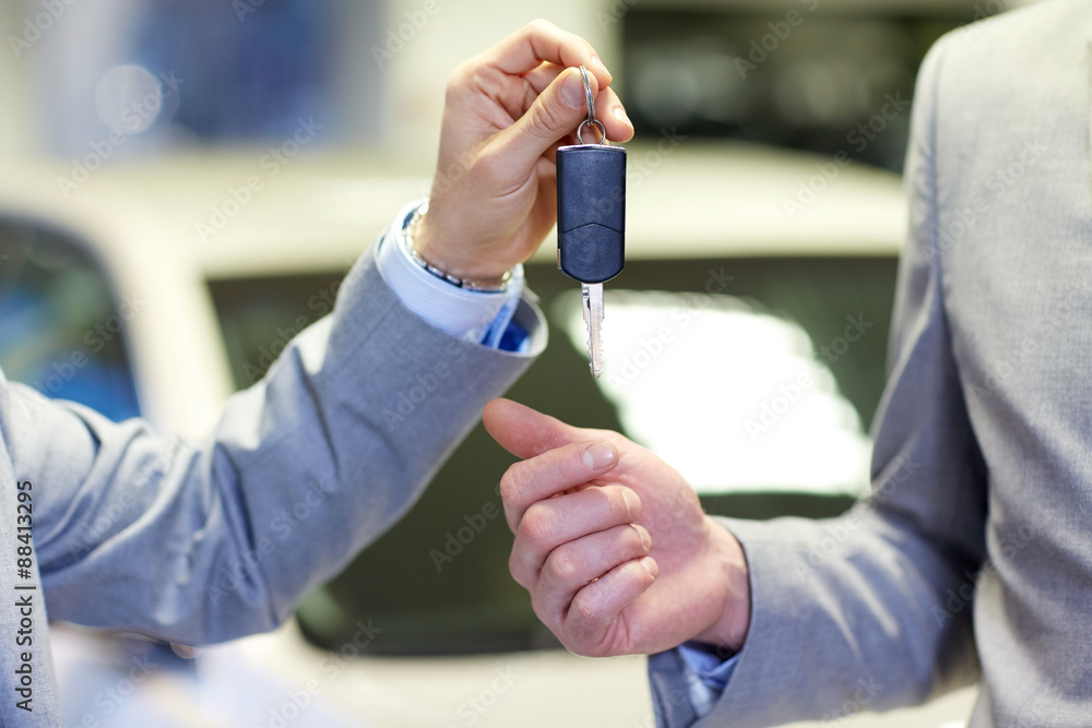 close up of male hands with car key in auto salon close up of male hands with car key in auto salon