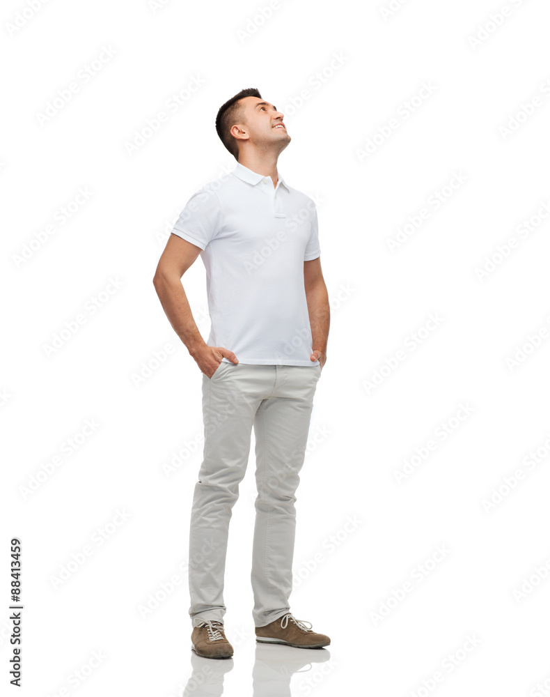 smiling man with hands in pockets looking up smiling man with hands in pockets looking up