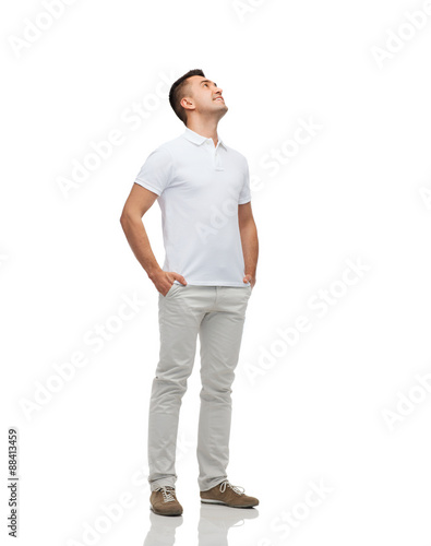 Obraz na plátne smiling man with hands in pockets looking up
