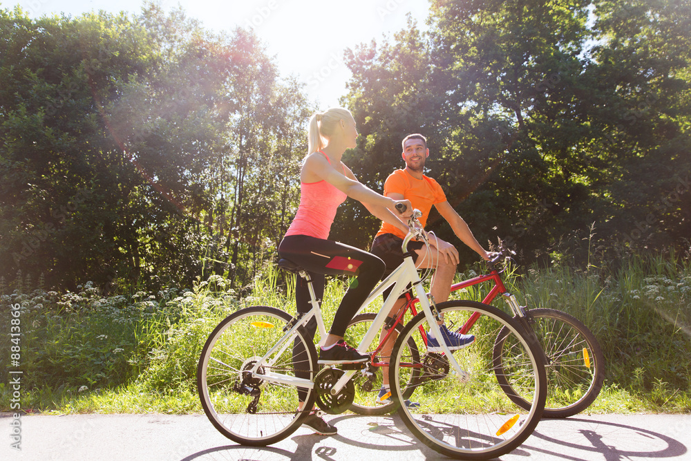 happy couple riding bicycle outdoors