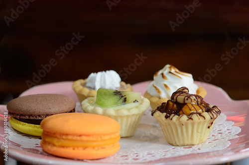 Dessert tartlet with magaron and kiwi fruit mixed on plate photo