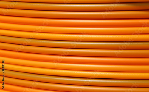 coils of orange plastic pipes for the installation of undergroun photo