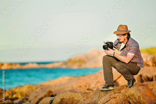 Young photographer taking photos at the beach 