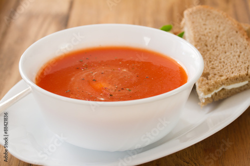 tomato soup in white bowl with sandwich