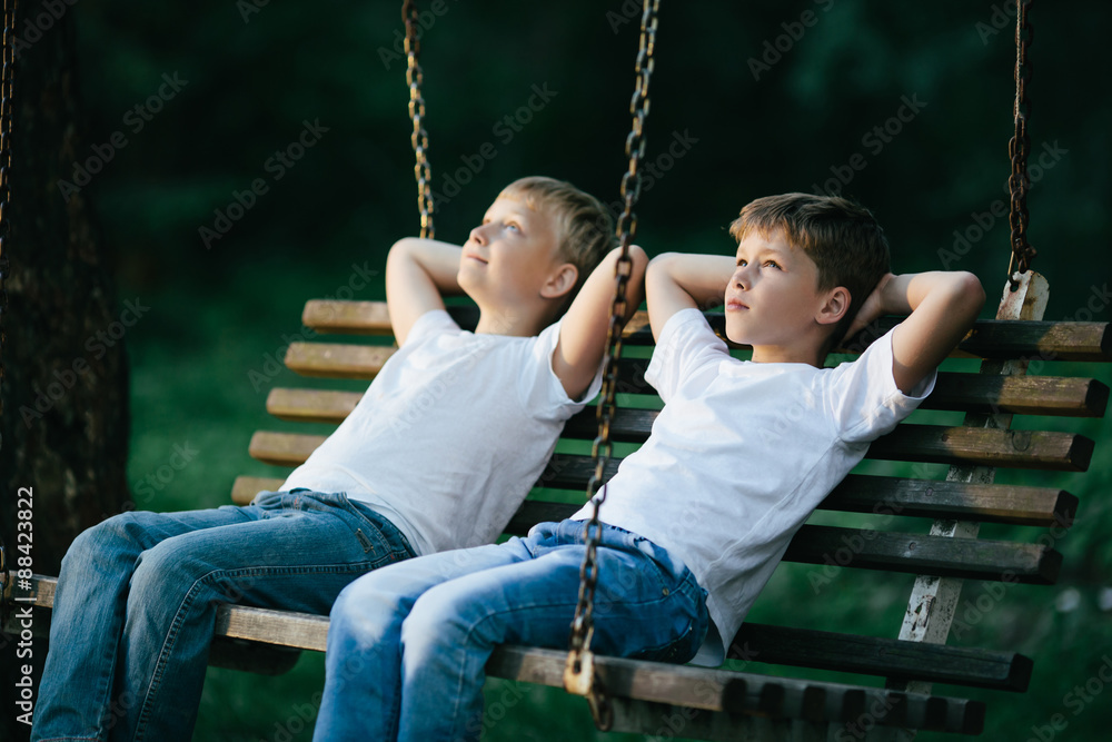 Obraz premium little boys dreaming on swing
