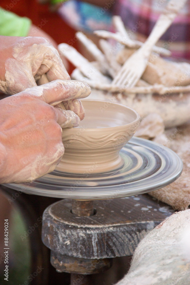 Fototapeta premium hands in the clay, four hands molded clay, the clay on a potter'