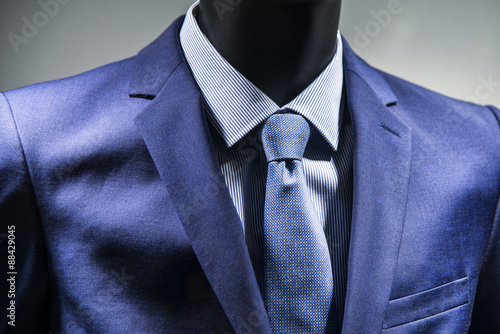 Close up of tie on elegant blue suit.