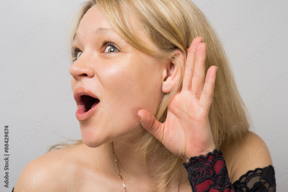 Overhears a woman put her hand to ear Overhears a woman put her hand to ear