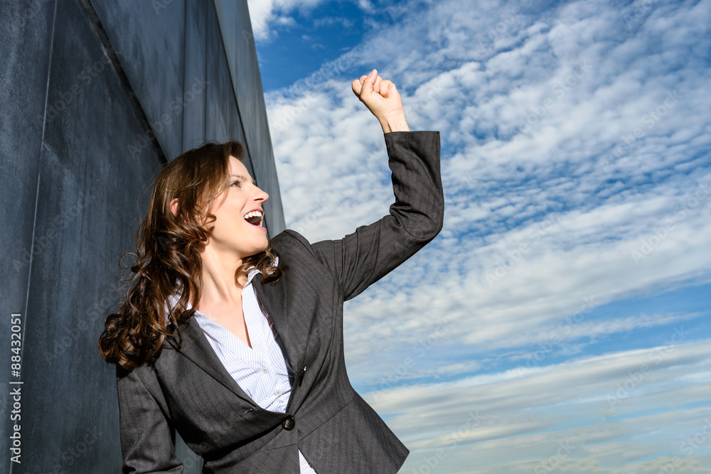 Young business woman in victory pose in front of the blue cloudy sky Young business woman in victory pose in front of the blue cloudy sky