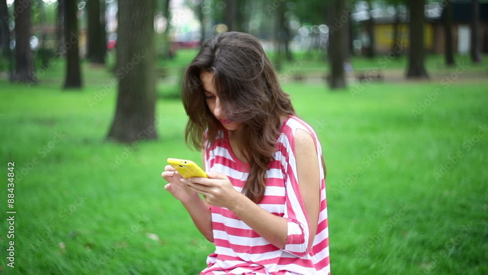 Beautiful woman sitting on a bench in the park with smartphone
Beautiful woman sitting on a bench in the park with smartphone