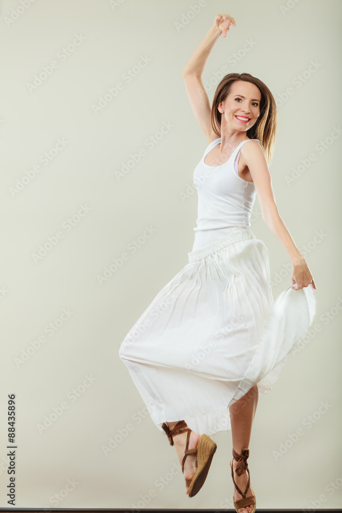 Naklejka premium Woman in summer white dress jumping