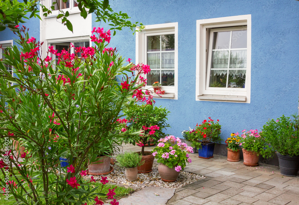 blaue Hausfront mit mediterraner Blumendekoration blaue Hausfront mit mediterraner Blumendekoration