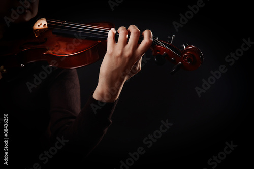 Violinist playing violin on dark background