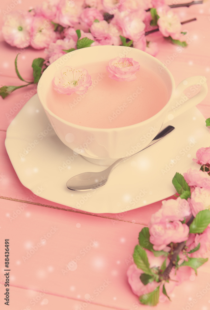 Cup of tea and beautiful fruit blossom on table