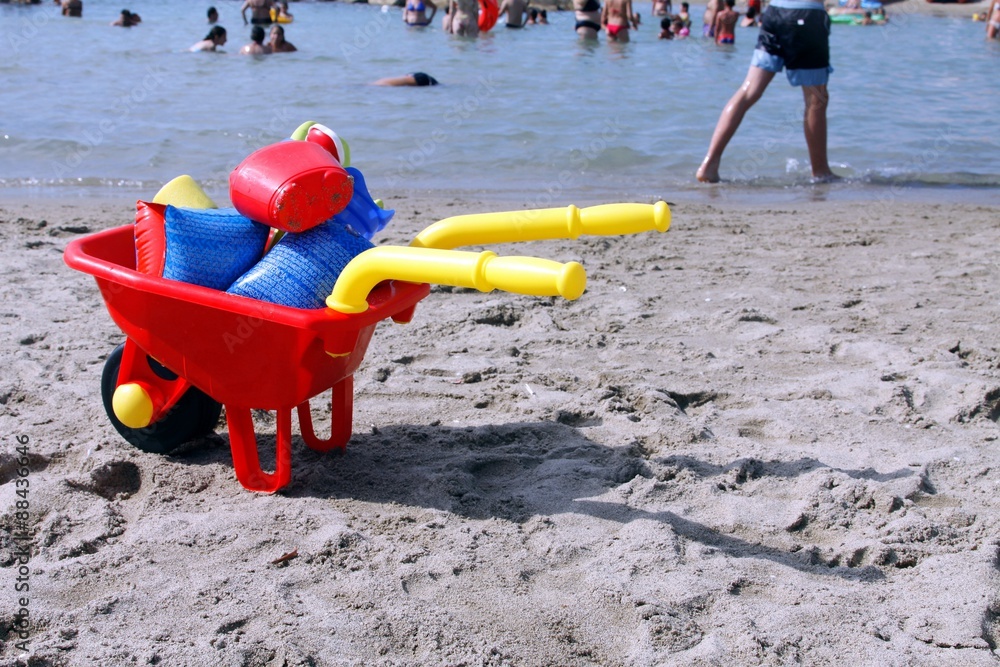 carriola con giochi acquatici sulla spiaggia carriola con giochi acquatici sulla spiaggia