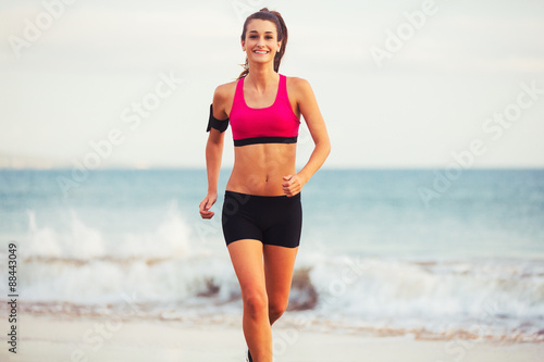 Sports Fitness Woman Running on the Beach at Sunset