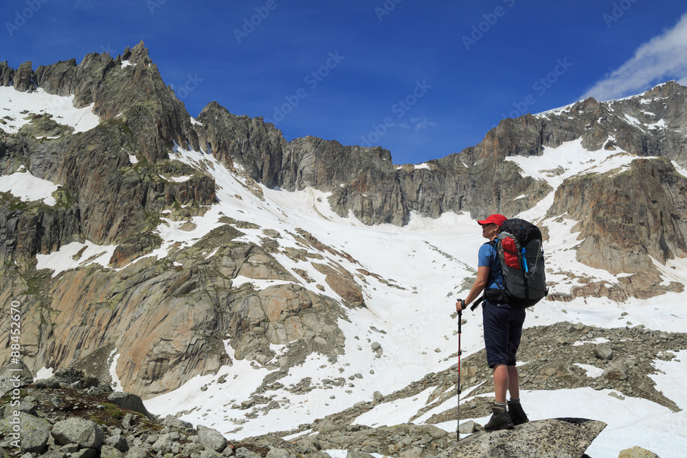 Female hiker enjoying the view of the mountains during a summer trekking vacation.