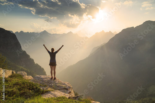 Female hiker enjoying the sunset in the mountains. photo