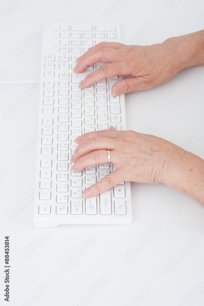パソコンのキーボードを操作する高齢者女性の手 パソコンのキーボードを操作する高齢者女性の手