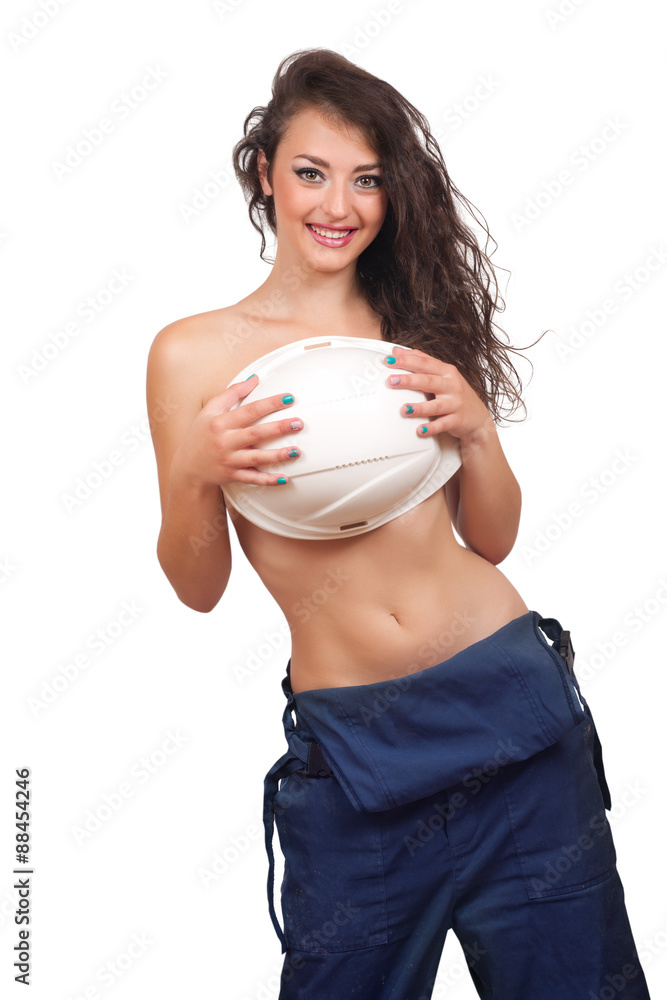 Sexy girl in a deflated coverall closes breast helmet on a white background Sexy girl in a deflated coverall closes breast helmet on a white background