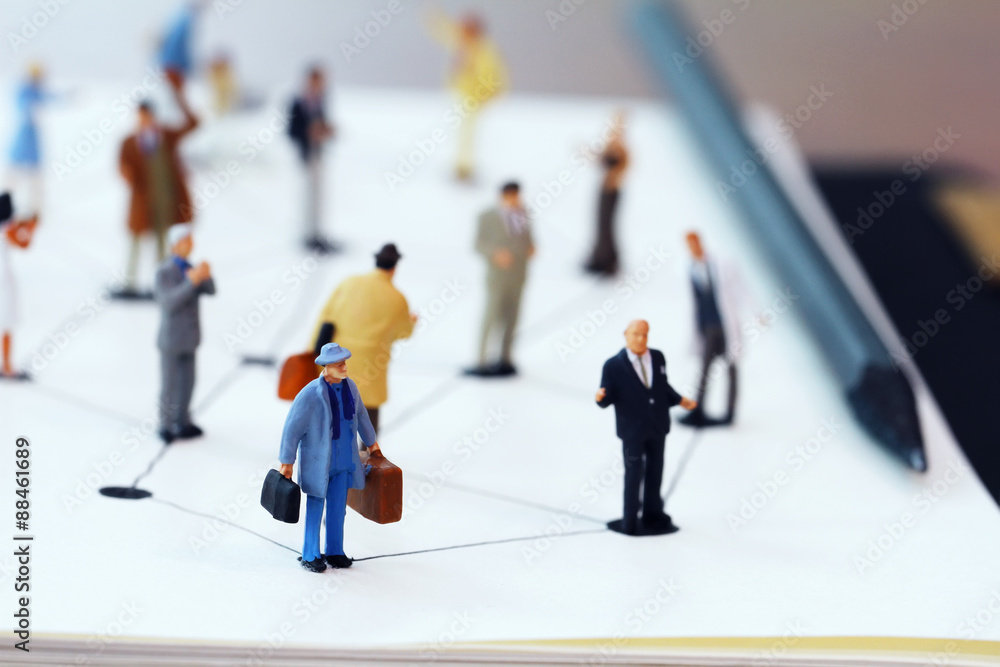 close up of miniature people with social network diagram on open close up of miniature people with social network diagram on open