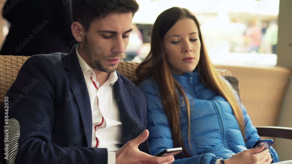 Young couple showing something to each other on smartphone in cafe in city
Young couple showing something to each other on smartphone in cafe in city