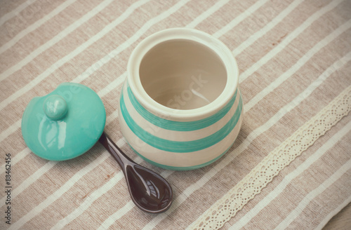 Green pastel porcelain jar and brown spoon in vintage style. photo