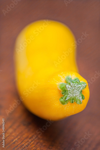 Fresh yellow courgette (zucchini) on wooden background.
Soft focus. photo