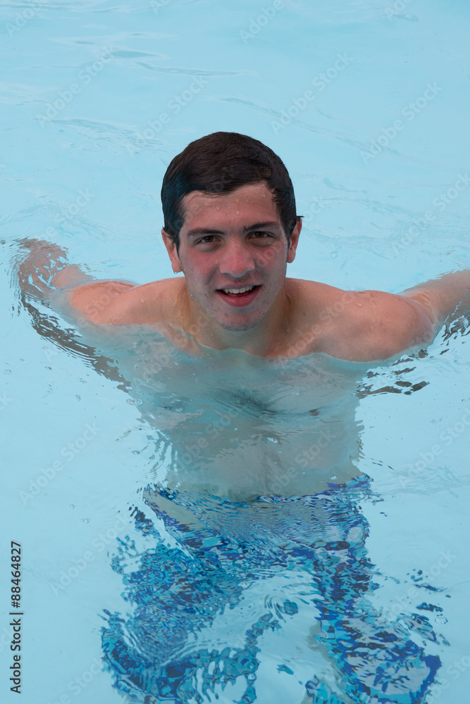 Young man in the pool at summertime