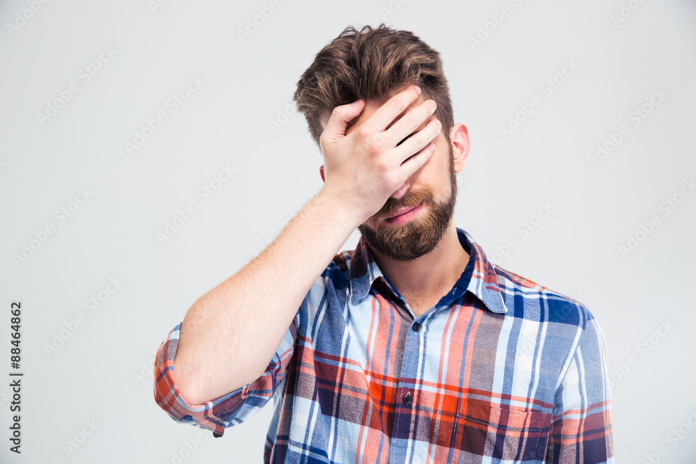 Portrait of upset man covering his face with hand Portrait of upset man covering his face with hand