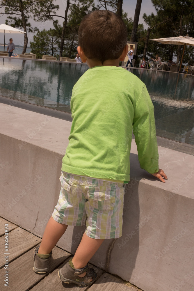 Little boy in front of the swimming pool Little boy in front of the swimming pool