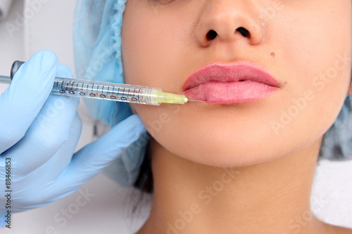 Beautiful woman gets an injection in her lips.