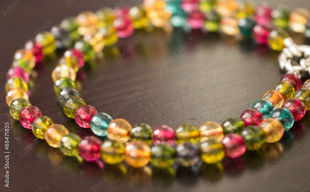 Necklace from glass beads of different colors on a dark surface close up
Necklace from glass beads of different colors on a dark surface close up