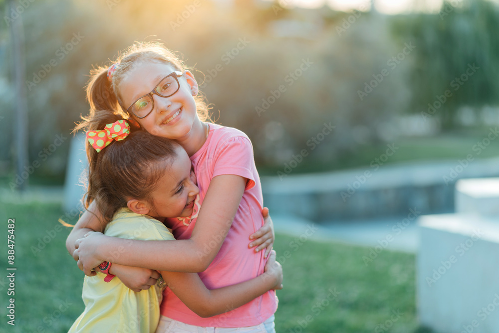 Two sisters are hugging in the park Two sisters are hugging in the park