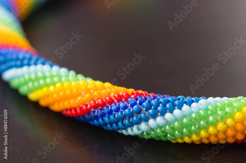 Fragment necklaces rainbow colors on dark wooden surface close-up