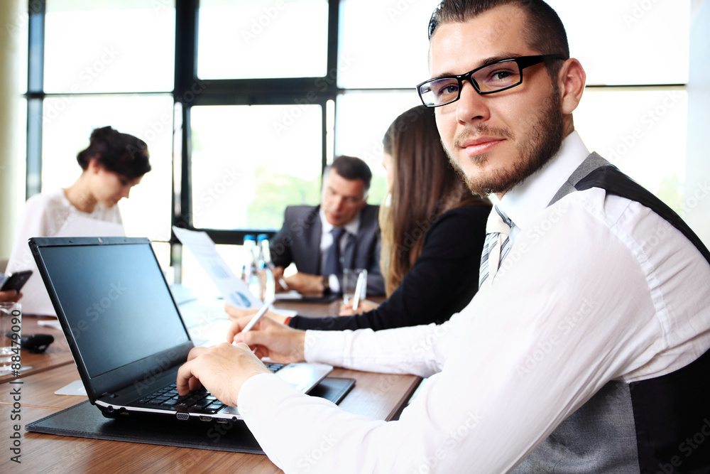 Businessman with colleagues in the background Businessman with colleagues in the background