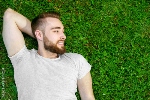 Young man lying on the grass in park