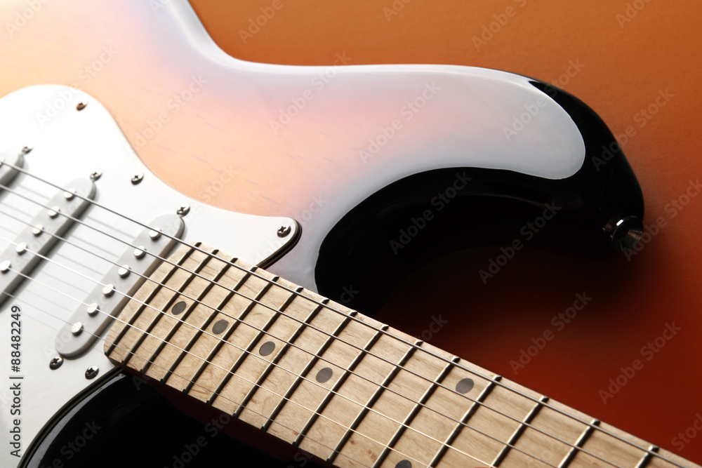 Obraz premium Orange electric guitar on redbackground