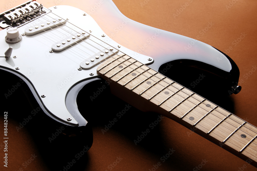 Fototapeta premium Orange electric guitar on redbackground