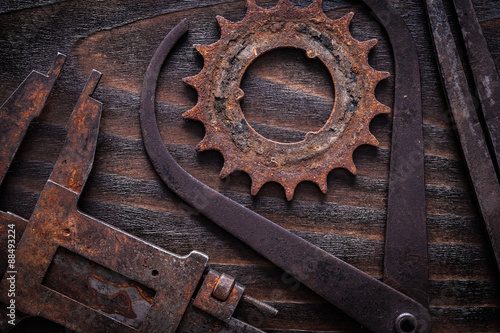 Set of rusty measuring calipers with cog- wheel on vintage dark 