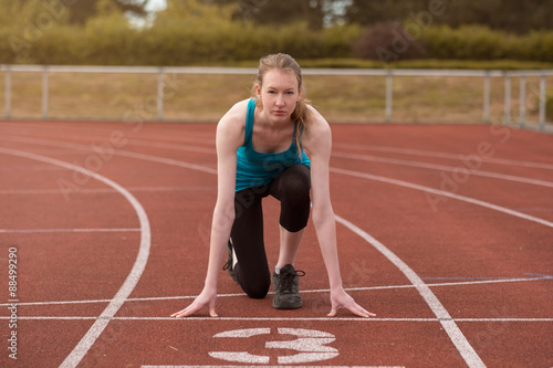 Young woman sprinter in the starter position