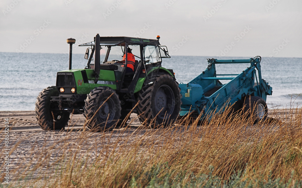 Obraz premium Tractor cleaning the beach