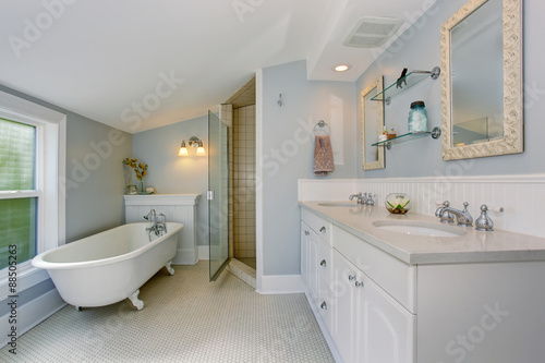 All white luxury master bathroom with vintage bathtub.