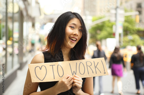 Wallpaper Mural A woman holding a sign saying "love to work" on a city street. Torontodigital.ca