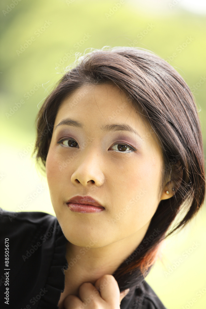 Outdoor portrait of young attractive woman with green background. Outdoor portrait of young attractive woman with green background.