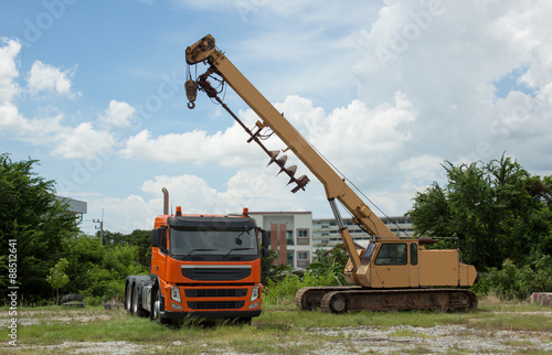 Car drilling drawbar trailer towing yellow-orange.