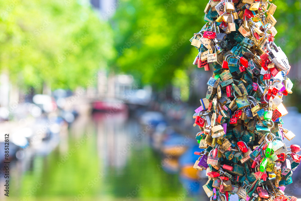 Colorful hundreds of padlocks-love locks on canal in Amsterdam
