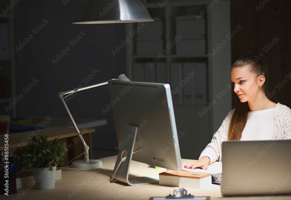 Young woman working in office, sitting at desk Young woman working in office, sitting at desk