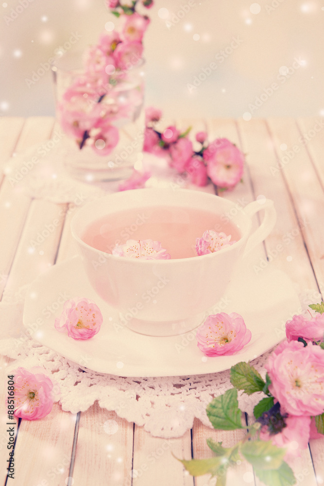 Cup of tea and beautiful fruit blossom on table
